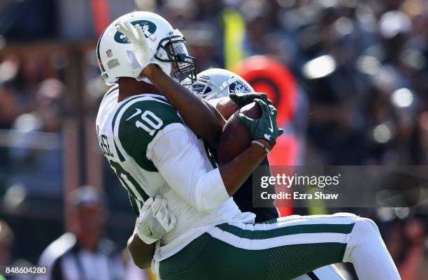 Jermaine Kearse of the New York Jets catches a touchdown while covered by David Amerson of the Oakland Raiders at Oakland-Alameda County Coliseum on...