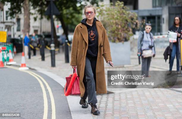 Nina Suess wearing brown wool coat, hoody, red Fendi bag outside Preen during London Fashion Week September 2017 on September 17, 2017 in London,...