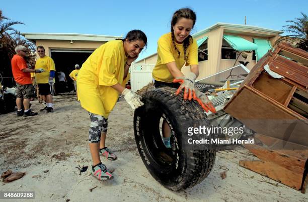 Sydney Rojers and Raquel Lopez left to right, volunteers from the Church of Jesus Christ of Latter-Day Saints, clear debris from a Monroe County...