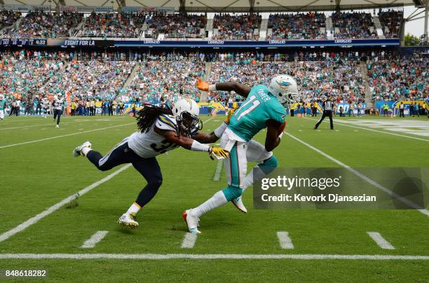 Wide receiver DeVante Parker of the Miami Dolphins slips past free safety Tre Boston of the Los Angeles Chargers as he makes a catch and runs for big...