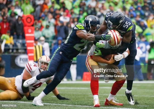 Free safety Earl Thomas of the Seattle Seahawks and defensive end Frank Clark work to sack quarterback Brian Hoyer of the San Francisco 49ers during...