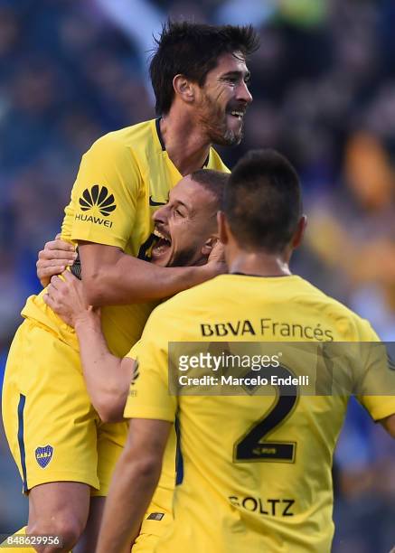 Pablo Perez of Boca Juniors celebrates with teammates Dario Bennedetto and Paolo Goltz after scoring the first goal of his team during a match...
