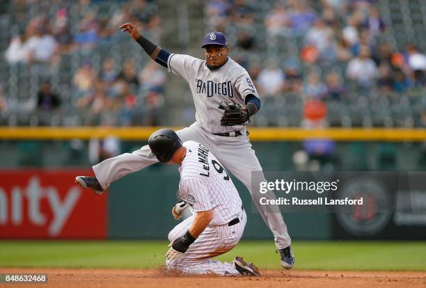 Erick Aybar of the San Diego Padres attempts to turn a double play as DJ LeMahieu of the Colorado Rockies slides into second base in the fifth inning...