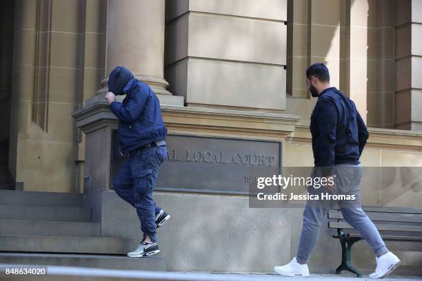 Supporters of Michael and Fadi Ibrahim, Mustapha Dib and Koder Jomaa have a cigarette break and hide their faces from the media at Sydney Central...