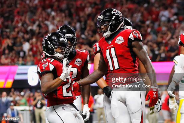 Devonta Freeman of the Atlanta Falcons celebrates with Julio Jones after scoring a 1-yard rushing touchdown during the first quarter against the...