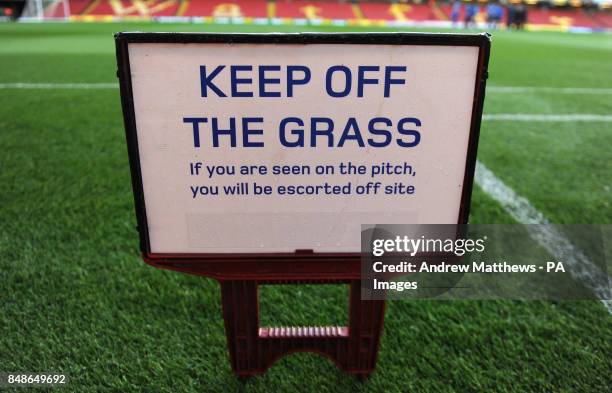 General view of a Keep Off the Grass sign on the pitch at Vicarage Road