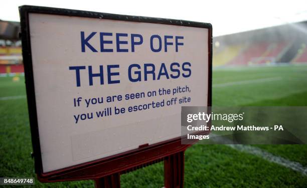 General view of a Keep Off the Grass sign on the pitch at Vicarage Road