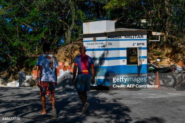 Men walk by an old police post in the Santa Marta favela, the first to be pacified by the Pacifier Police Unit state programme to secure poor...