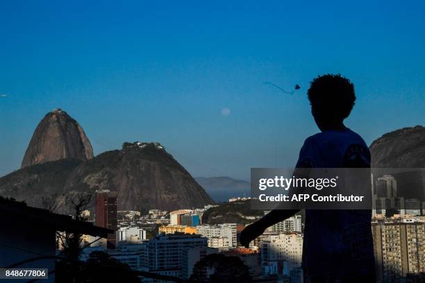 Boy flies a kite in the Santa Marta favela, the first to be pacified by the Pacifier Police Unit state programme to secure poor communities by...