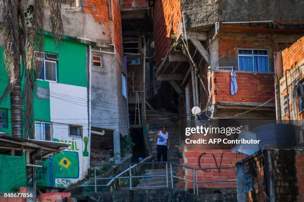 Woman is seen walking along an alley near a graffiti reading CV in Santa Marta, the first to be pacified by the Pacifier Police Unit state programme...