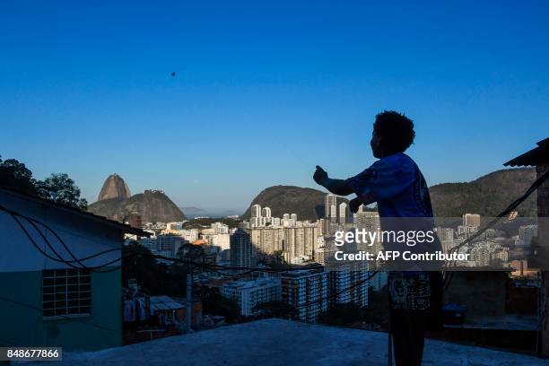 Boy flies a kite in the Santa Marta favela, the first to be pacified by the Pacifier Police Unit state programme to secure poor communities by...