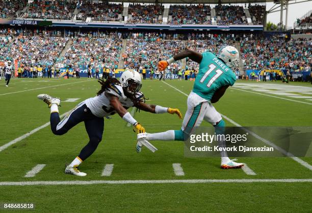 Wide receiver DeVante Parker of the Miami Dolphins slips past free safety Tre Boston of the Los Angeles Chargers as he makes a catch and runs for big...