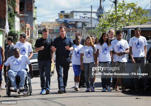 Prime Minister David Cameron and Project director Luke Dowdney walk in the Mare Favela, north of Rio de Janeiro, where he visited the Luta Pela Paz...