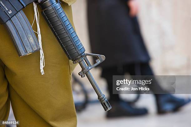 an israeli soldier's rifle at the western wall. - israel out stock pictures, royalty-free photos & images