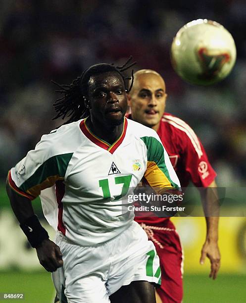 Ferdinand Coly of Senegal wins the race for the loose ball ahead of Hasan Sas of Turkey during the FIFA World Cup Finals 2002 Quarter Finals match...