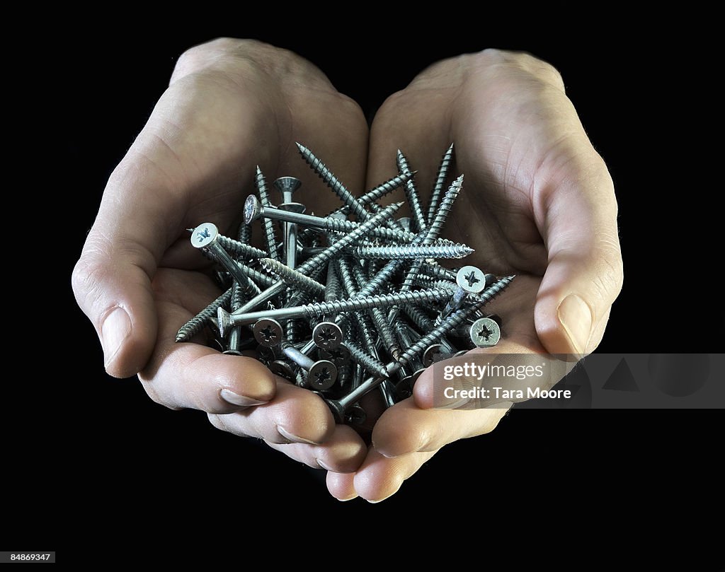 Hands holding screws