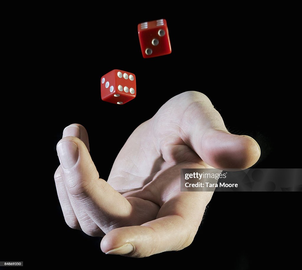 Hands throwing up dice