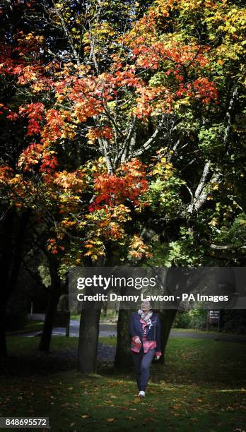 Woman under autumn leaves in Pollok Park in Glasgow, Scotland.