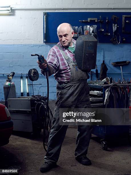 portrait of car mechanic with welding mask - auto mechaniker stock-fotos und bilder
