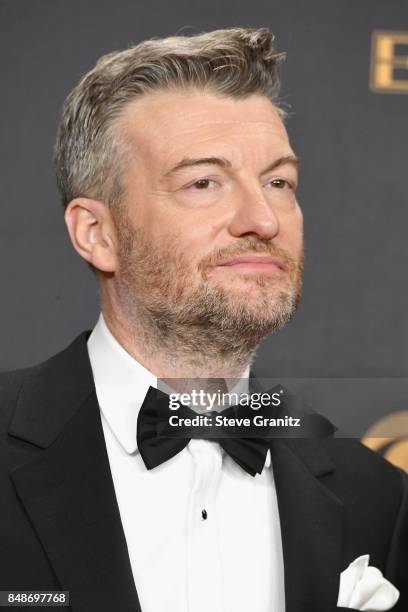 Producers Charlie Brooker, winner of the award for Outstanding Television Movie for 'Black Mirror,' poses in the press room during the 69th Annual...