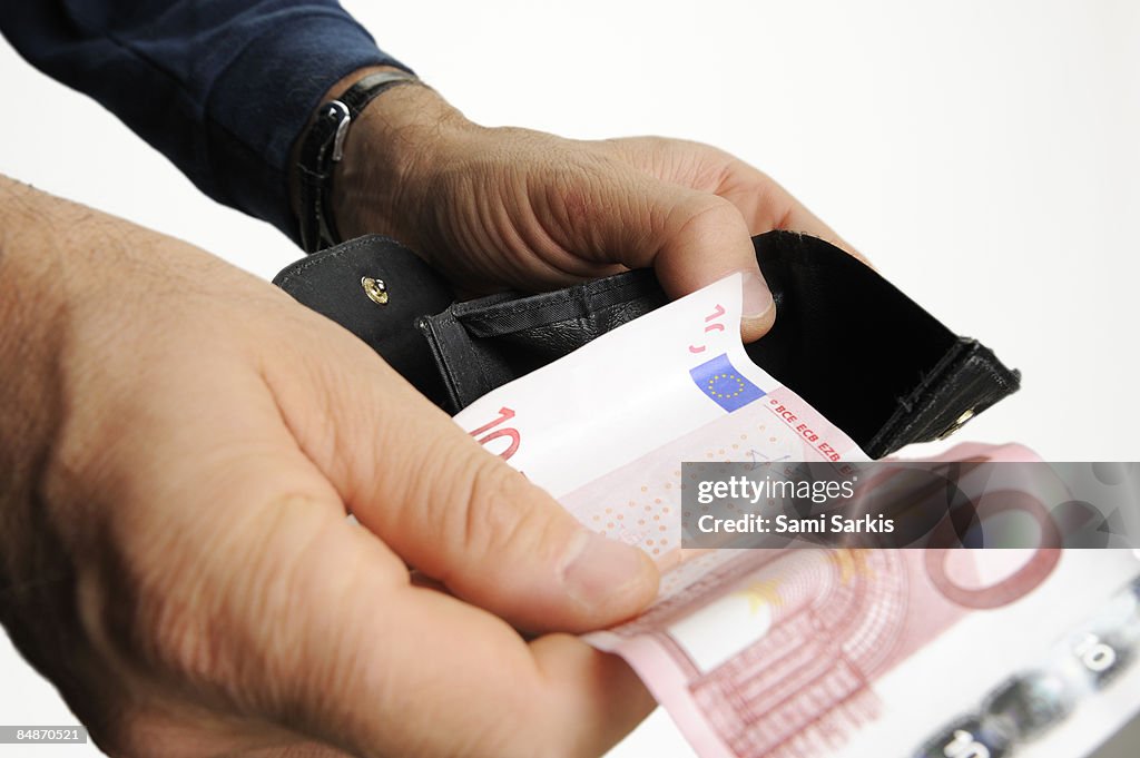 Man with a ten euros bill out of wallet