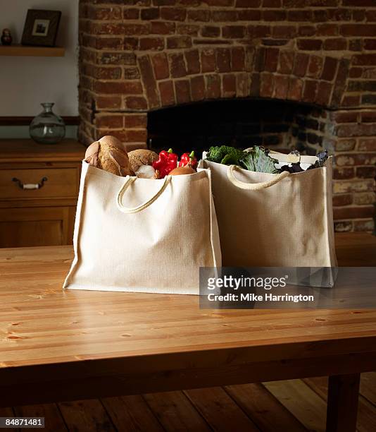 canvas full of organic produce on kitchen table - table brick wall wood stockfoto's en -beelden