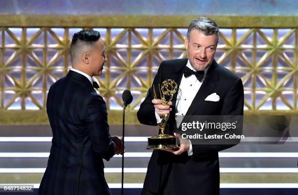 Writer Charlie Brooker accepts the Outstanding Television Movie award for 'Black Mirror: San Junipero onstage from actor BD Wong during the 69th...