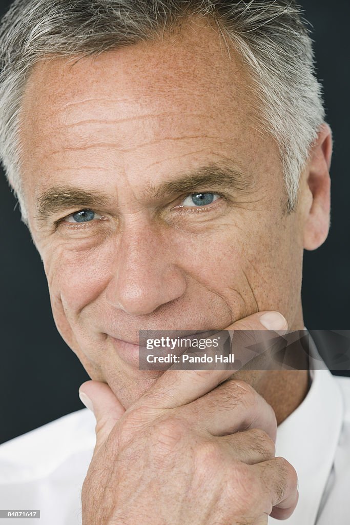 Man smiling, hand on chin, close-up