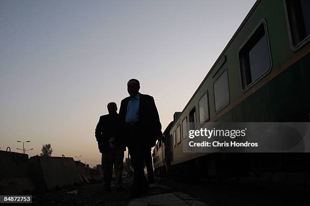 Passengers mill about in the pre-dawn hours before boarding a commuter train from the southern neighborhood of Dora to Central Baghdad February 18,...