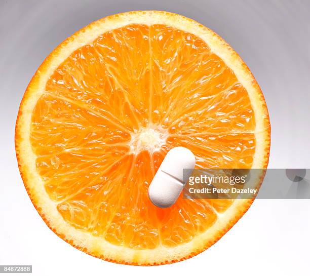 vitamin c pill/ tablet on orange slice - vitamin c stock-fotos und bilder