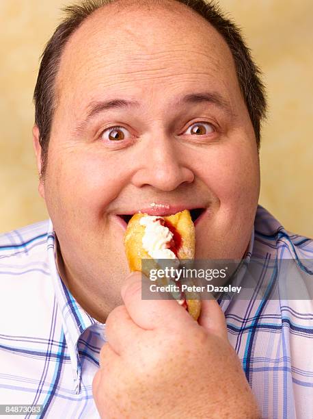 obese man eating cream cake. - fat people eating donuts 個照片及圖片檔