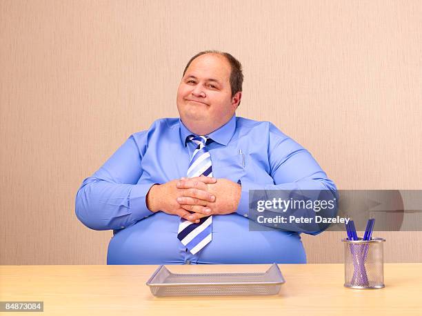 obese man at office desk. - fat cat stock pictures, royalty-free photos & images