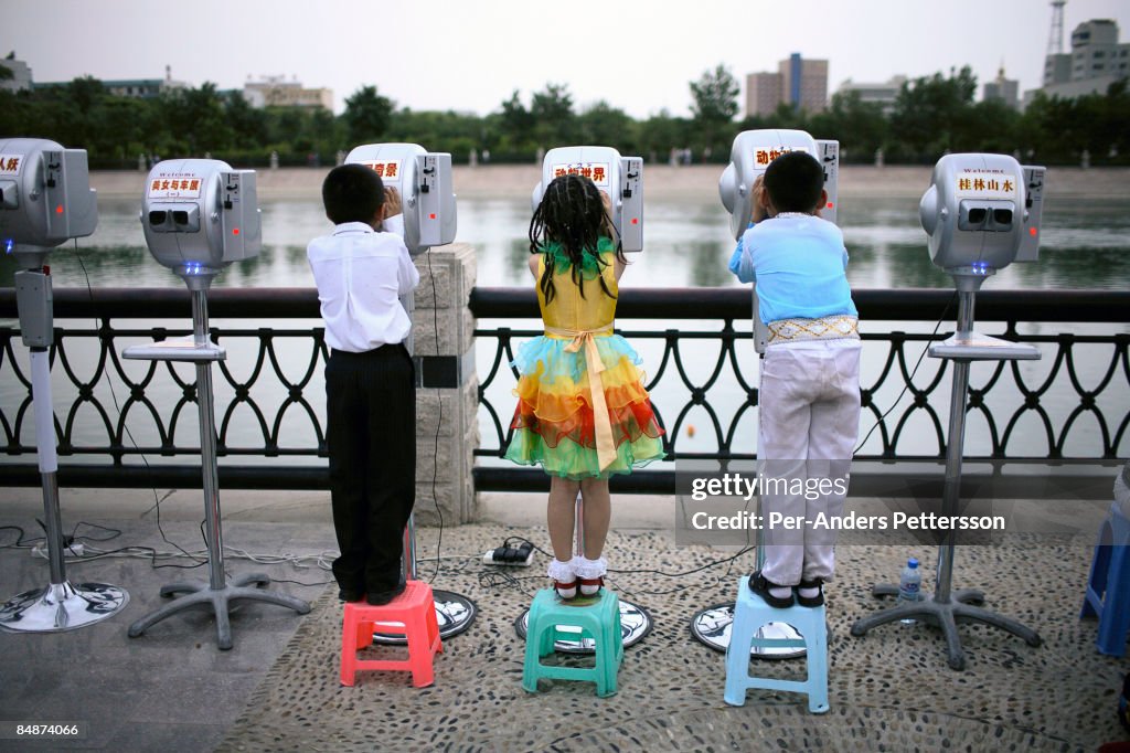 Children look through binoculars in Kurle, China.