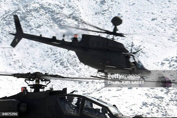 Kiowa helicopter flies over an Apache helicopter as they journey towards FOB Morales-Frazier in Nijrab on February 17, 2009. The deterioration in...