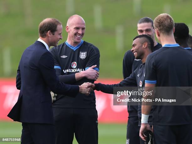 The Duke of Cambridge shakes hands with England's Ashley Cole after the training session during the official launch of The Football Association's...