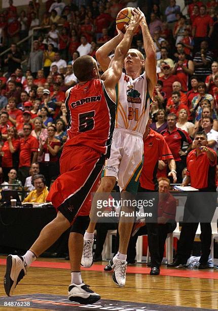John Rillie of the Crocodiles shoots over Adam Caporn of the Wildcats during the NBL quarter final match between the Perth Wildcats and the...