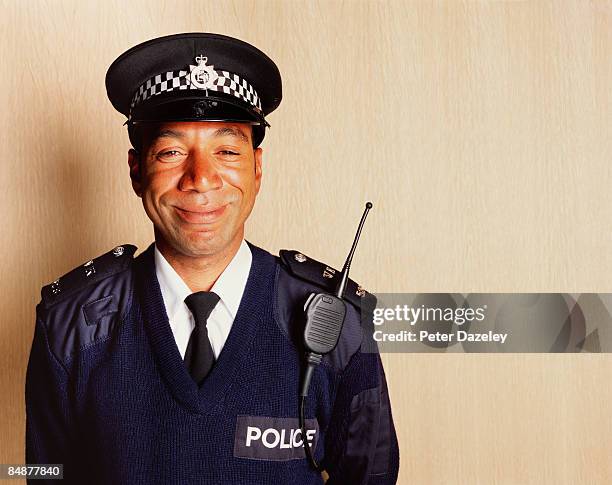 smiling black british police constable - uniforme della polizia foto e immagini stock