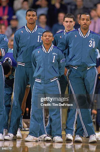 Mugsy Bogues of the Charlotte Hornets stands with his teammates before an NBA game at Charlotte Colesium in 1989.