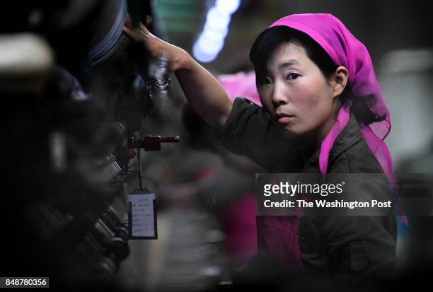 Female worker monitors newly harvested silk machinery in the first stage of processing at the Kim Jong Suk Silk Mill in Pyongyang, North Korea on May...