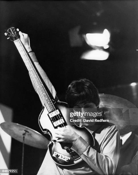 Paul McCartney of English rock and pop group The Beatles tunes up his Hofner 500/1 violin bass guitar on stage during rehearsals for the ABC...