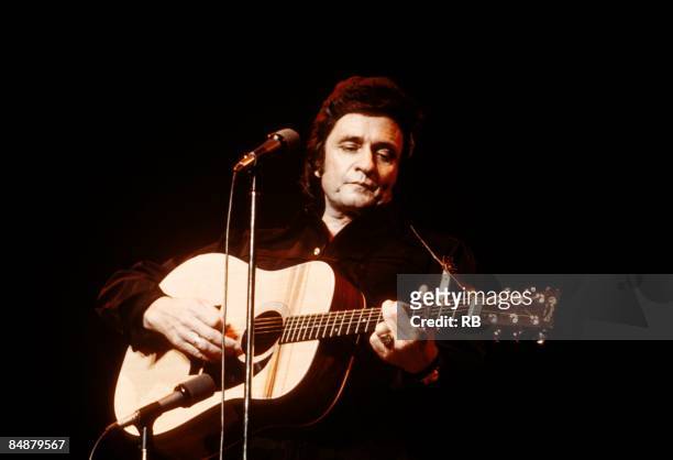 Photo of Johnny CASH and Johnny CASH; Johnny Cash performing on stage