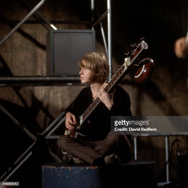 English musician and guitarist Brian Jones of rock group The Rolling Stones plays a sitar during a performance by the band on the set of the...