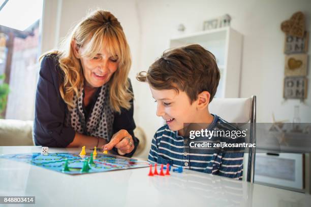 großmutter und enkel bretter spiel - familie brettspiel stock-fotos und bilder
