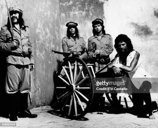 Photo of LEMMY and MOTORHEAD dressed in military uniforms wirth swords, guns and a cannon in a studio in Pimlico, London in July 1984. Left to Right:...
