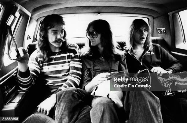 Photo of Geddy LEE and RUSH and Alex LIFESON and Neil PEART, L-R: Neil Peart, Geddy Lee, Alex Lifeson - posed, group shot - sitting in back of car on...