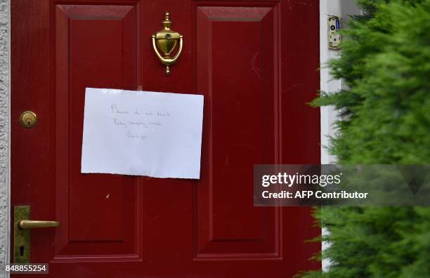 Note on a front door to a house reads "Please do not knock-Baby Sleeping" near to a police cordon by a house in Sunbury, west of London, on September...