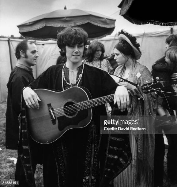 Scottish singer and musician Donovan posed with an acoustic guitar backstage at a festival circa 1967.