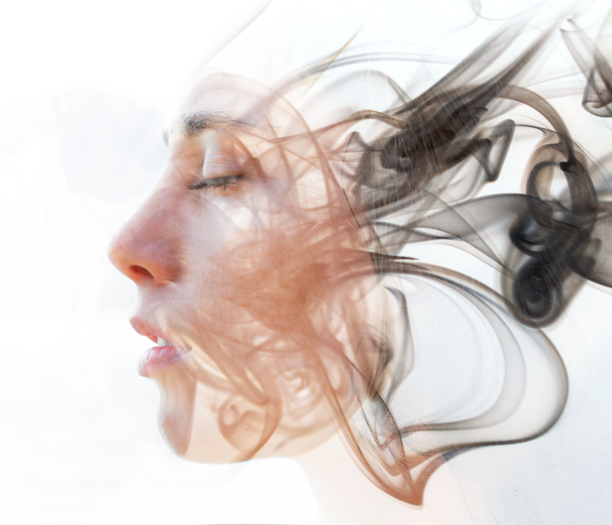 Double exposure portrait of a young fair-skinned woman and a smoky texture dissolving into her facial features Double exposure portrait of a young fair-skinned woman and a smoky texture dissolving into her facial features