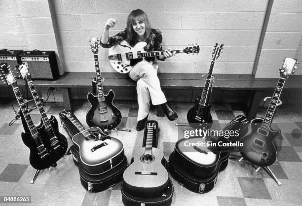 Photo of Alex LIFESON and RUSH, Alex Lifeson posed, backstage with guitar collection on All The World's A Stage tour