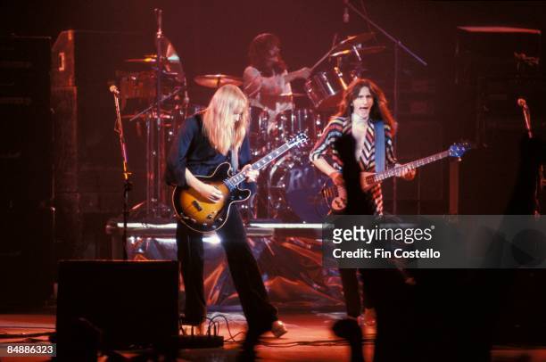 Photo of RUSH; L-R: Alex Lifeson, Neil Peart and Geddy Lee performing live onstage on All The World's A Stage tour,